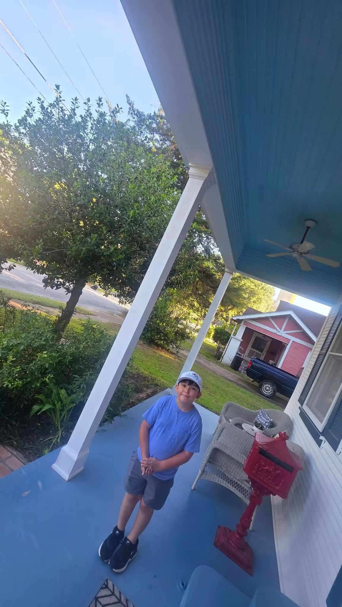 Person standing on the completed porch beside the finished custom column wraps