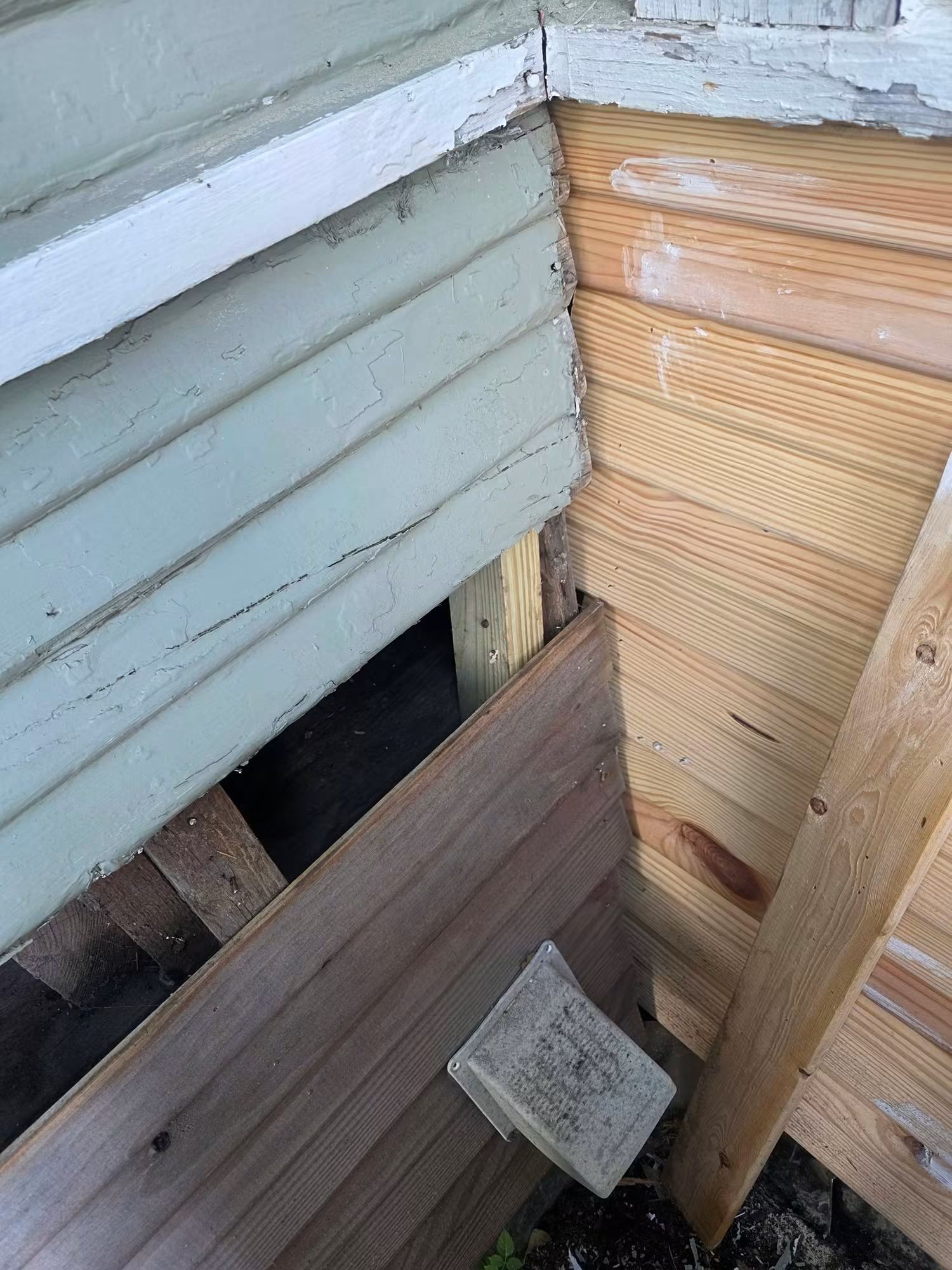 Deteriorated wood siding exposed at an exterior corner