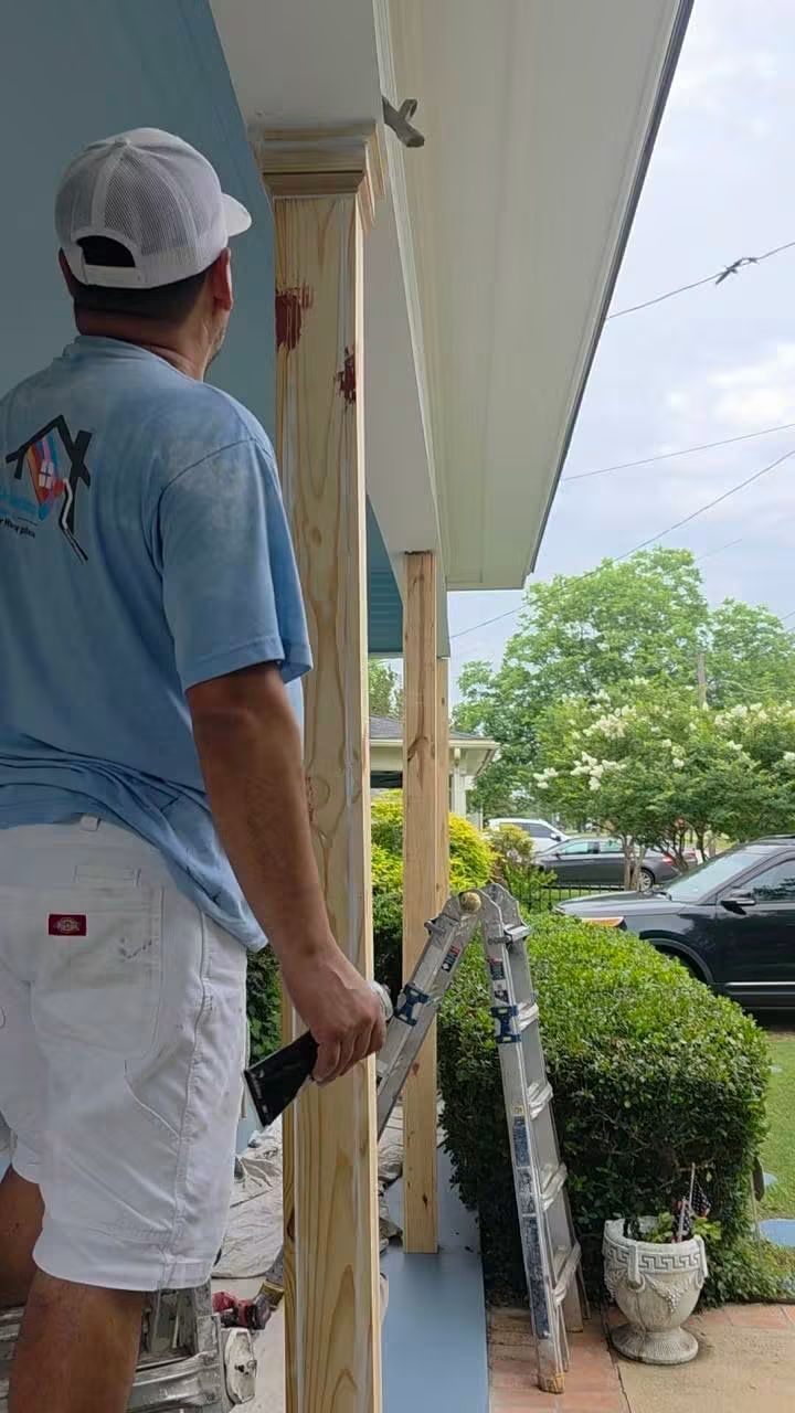 Finished porch corner showing the painted custom columns, trim, blue ceiling, and blue floor