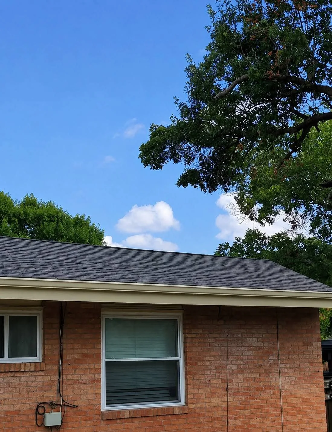 Finished brick home with the entirely new roof, painted exterior trim, and new gutters