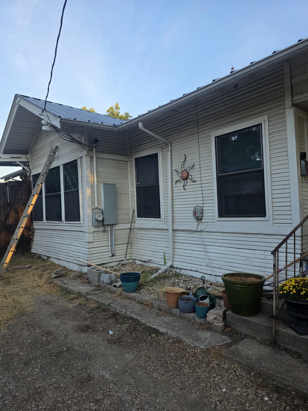 The bungalow’s worn white side wall before the restoration began