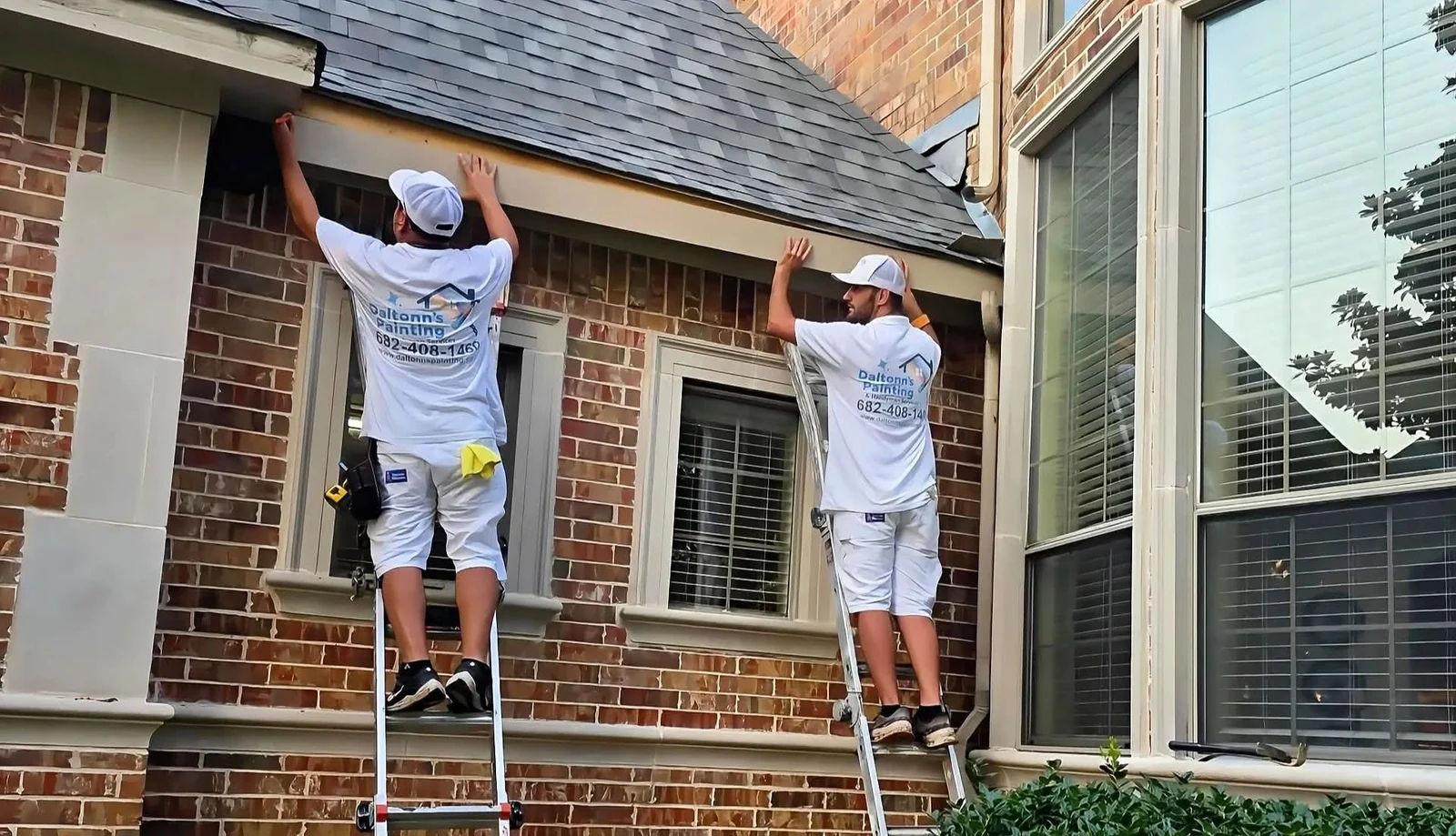 Two Daltonn’s team members working from ladders on exterior trim