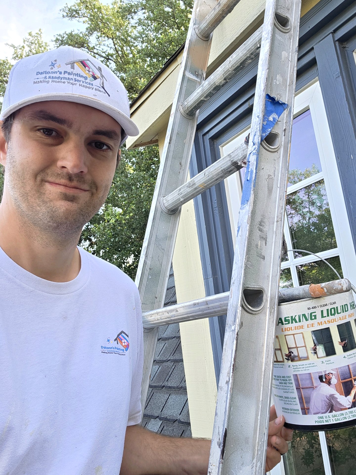 Daltonn beside a ladder during an exterior painting project