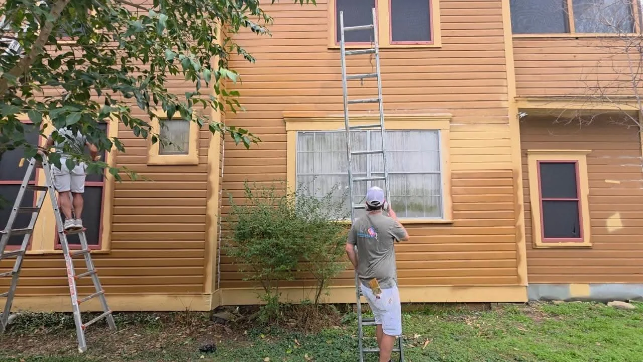 Wide view of exterior painting work across the side elevation