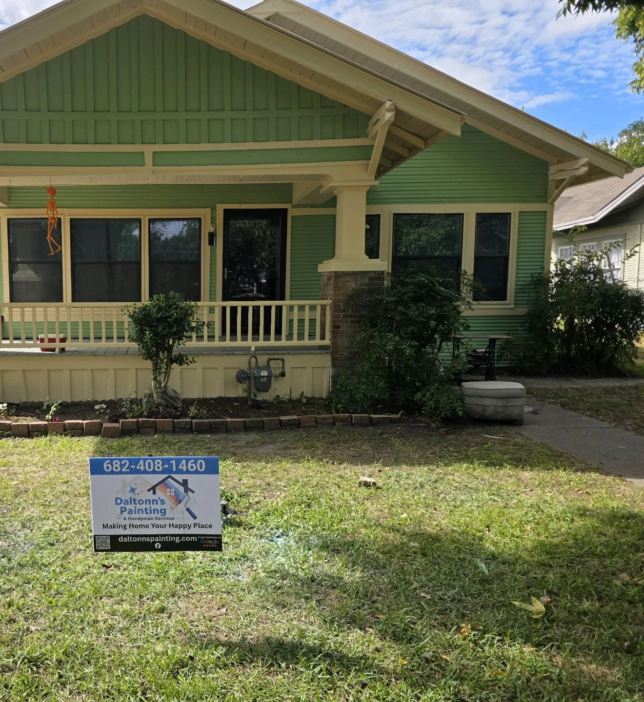 Finished green bungalow with cream trim and a Daltonn’s yard sign in the front yard