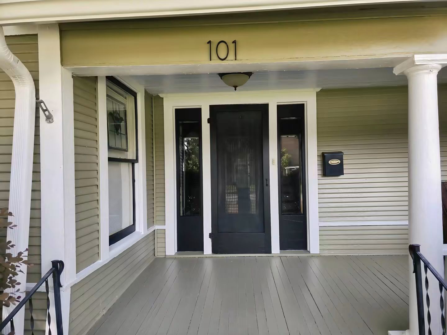 Finished front entry with contrasting door, windows, columns, siding, and trim