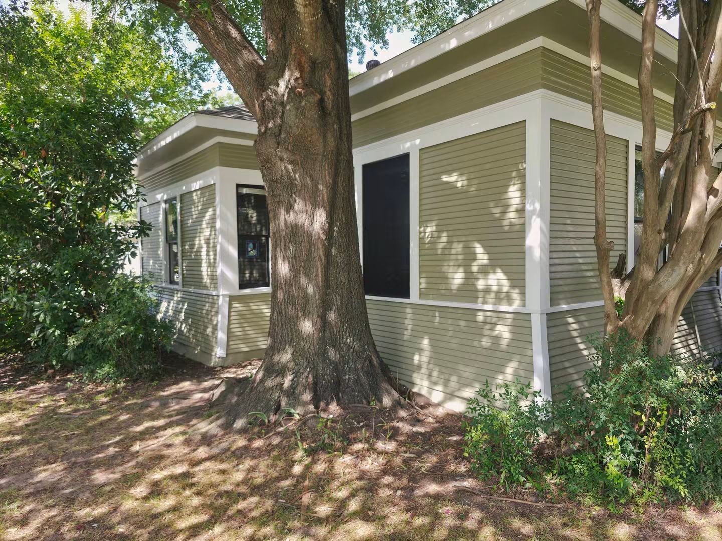 Wide finished side view after the lower exterior wall was rebuilt and the siding, windows, and trim were completed