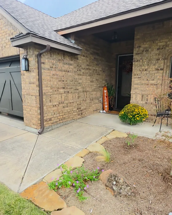Garage corner and front porch with the original tan and brown brick before limewash