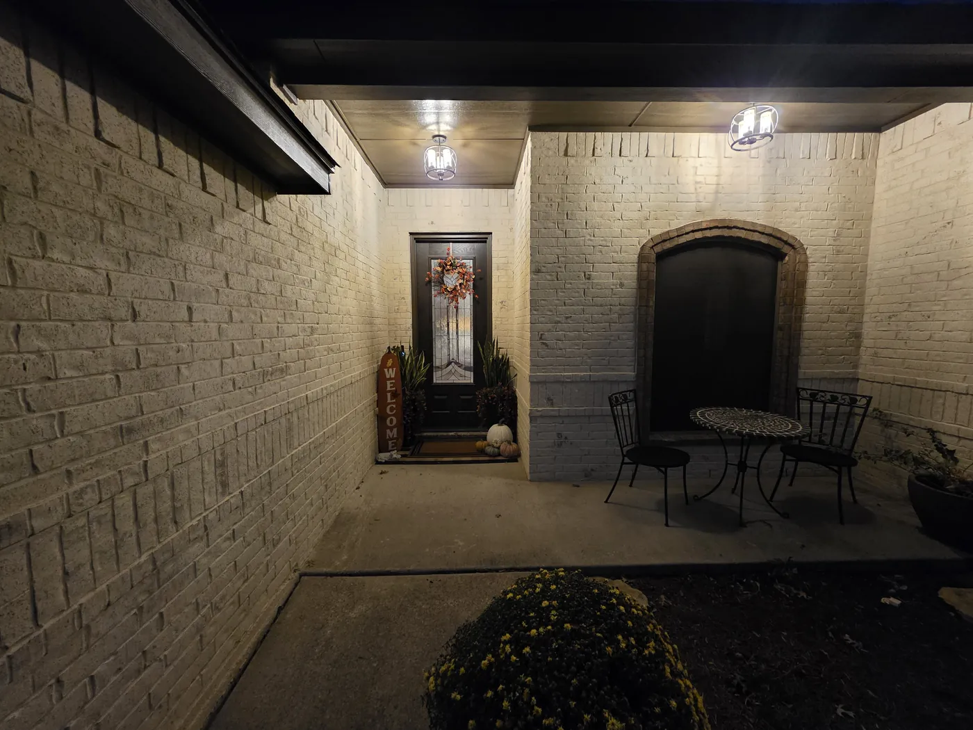 Limewashed front porch lit up at night