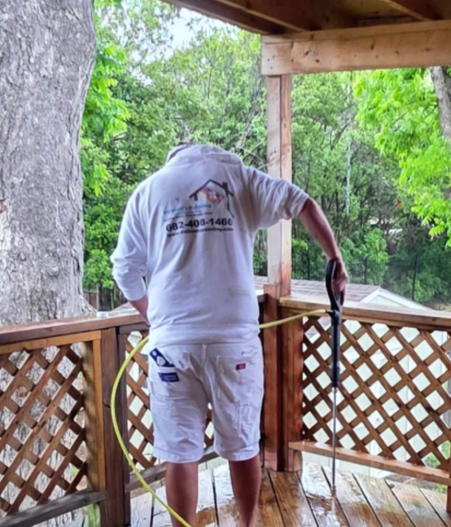Crew member applying a finish to the covered deck railing