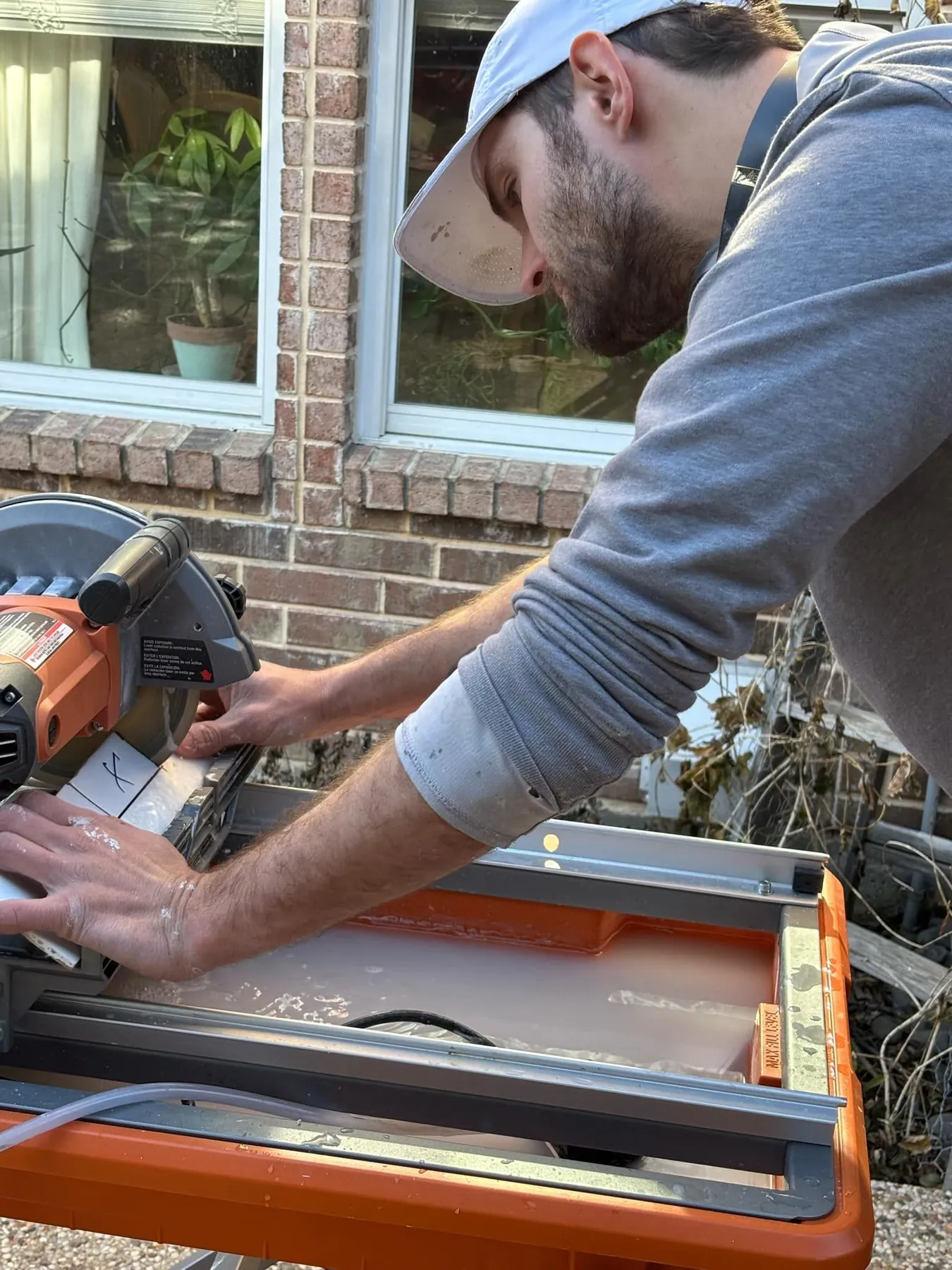 Tile being cut outside with a wet saw