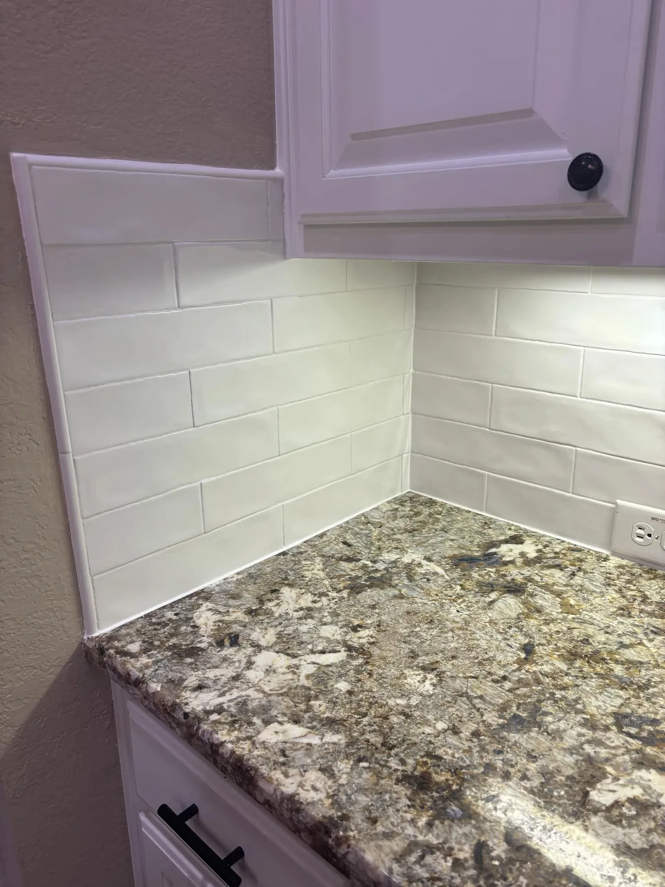 Finished white tile backsplash at the kitchen corner