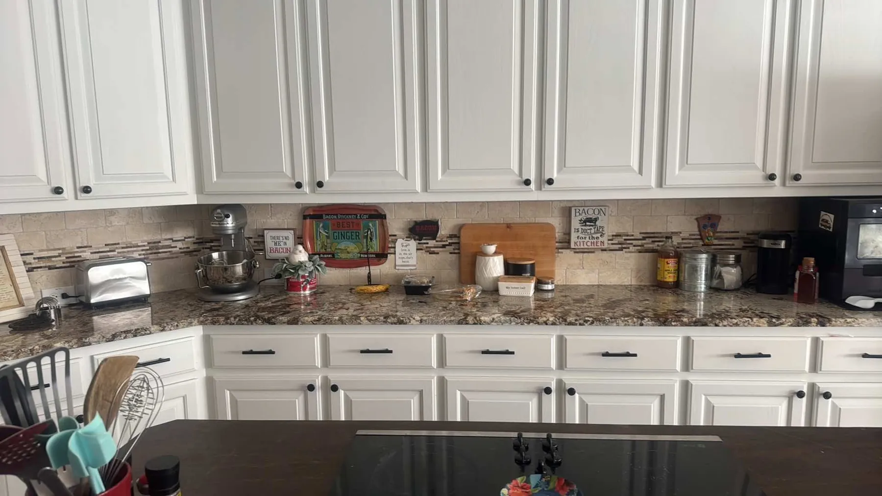 White kitchen with the original travertine and glass-mosaic backsplash before the update