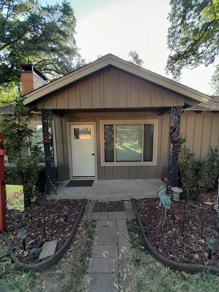 Finished-looking gray front of the same cottage, without a visible work setup