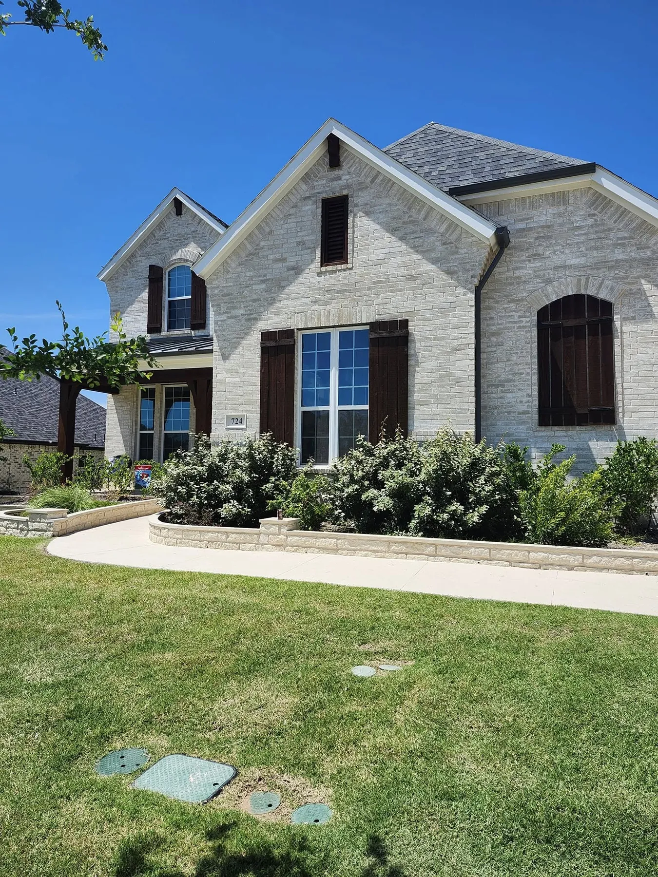 Wide view of the limestone home with coordinated dark exterior details