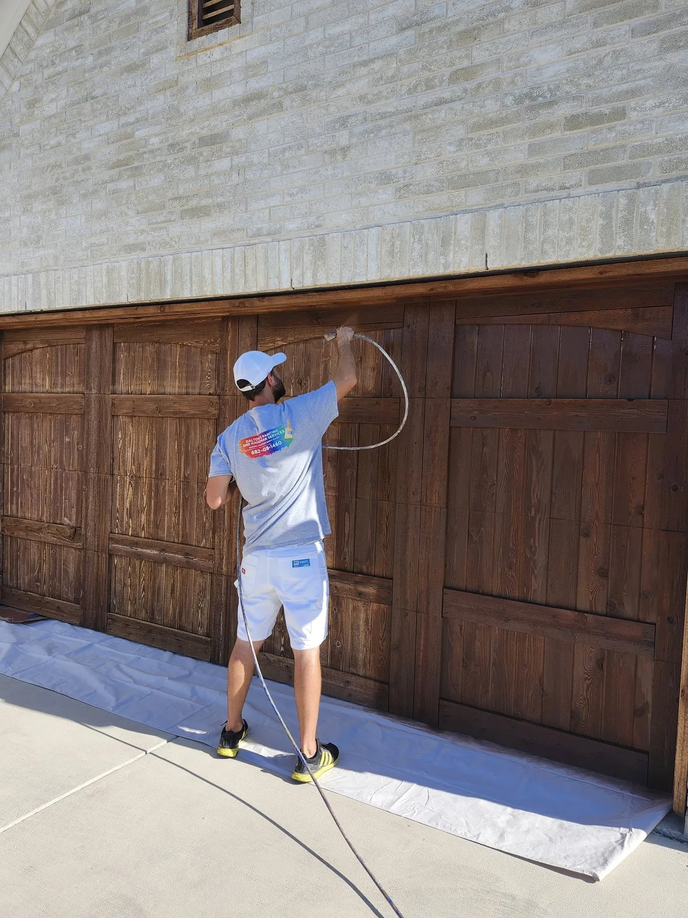 Daltonn applying the finish across the garage-door panels