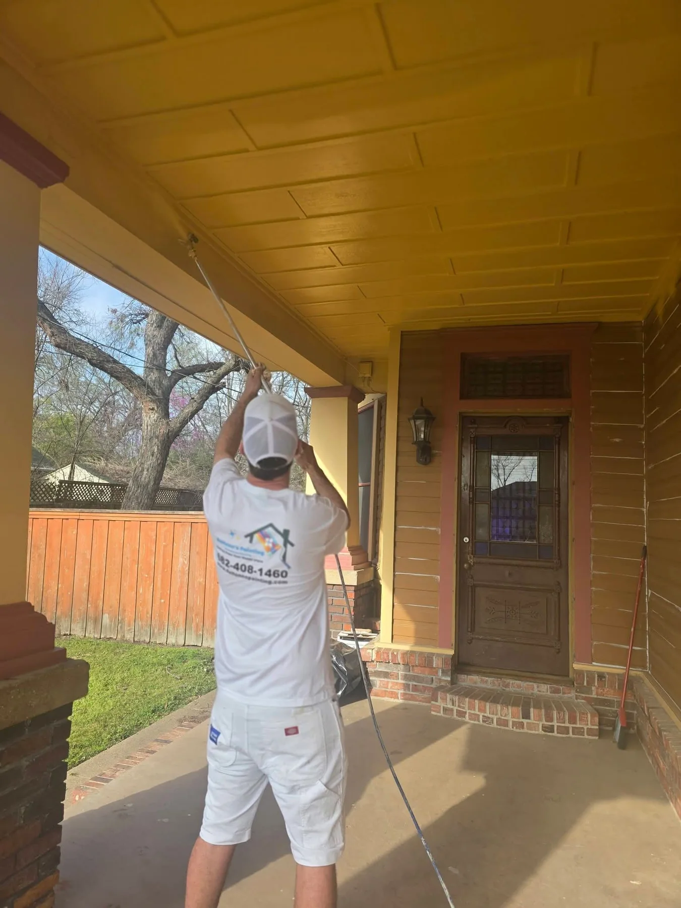 Porch ceiling being painted during the exterior restoration