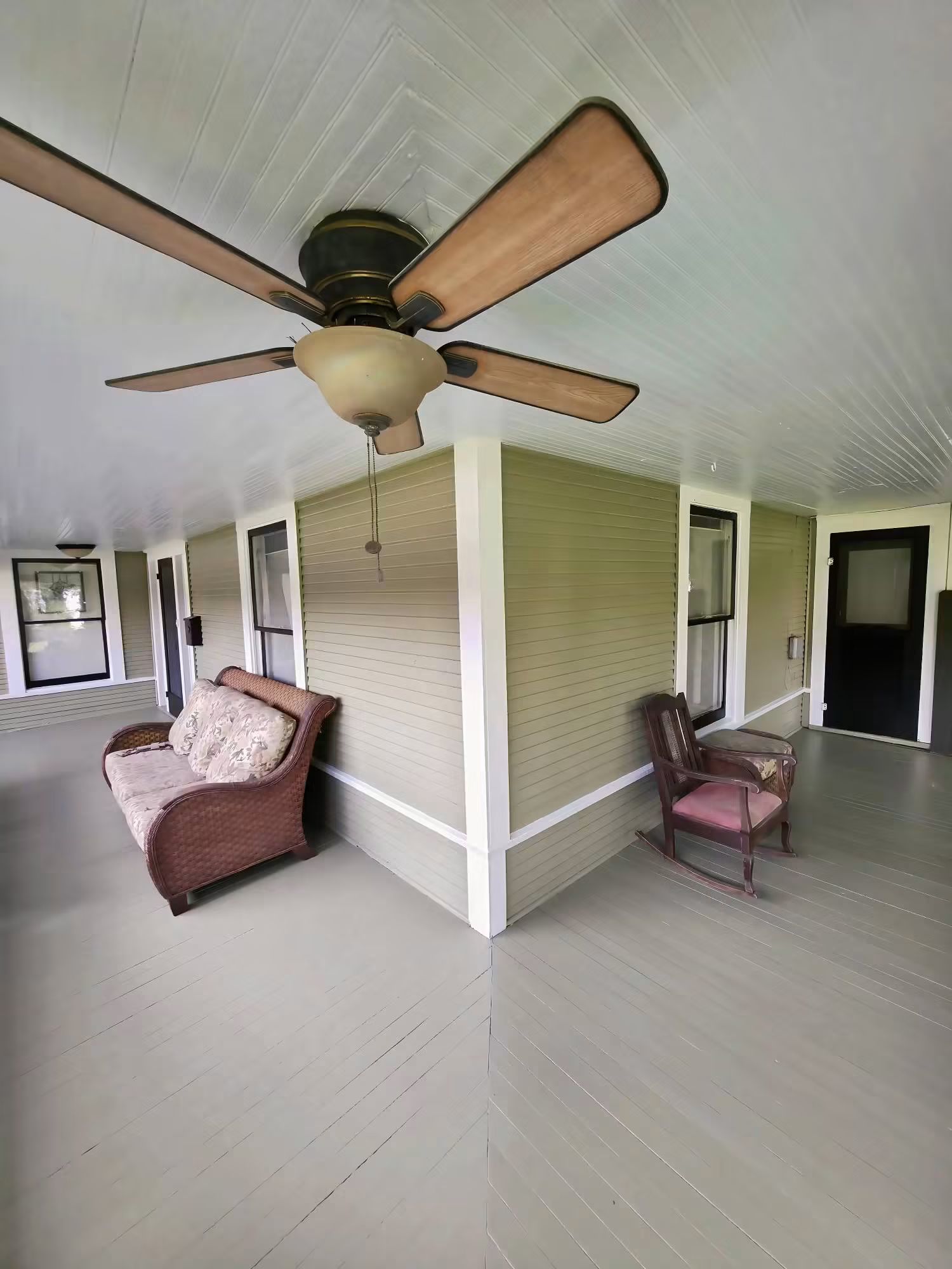 Finished covered porch with painted floor, ceiling, siding, windows, and doors