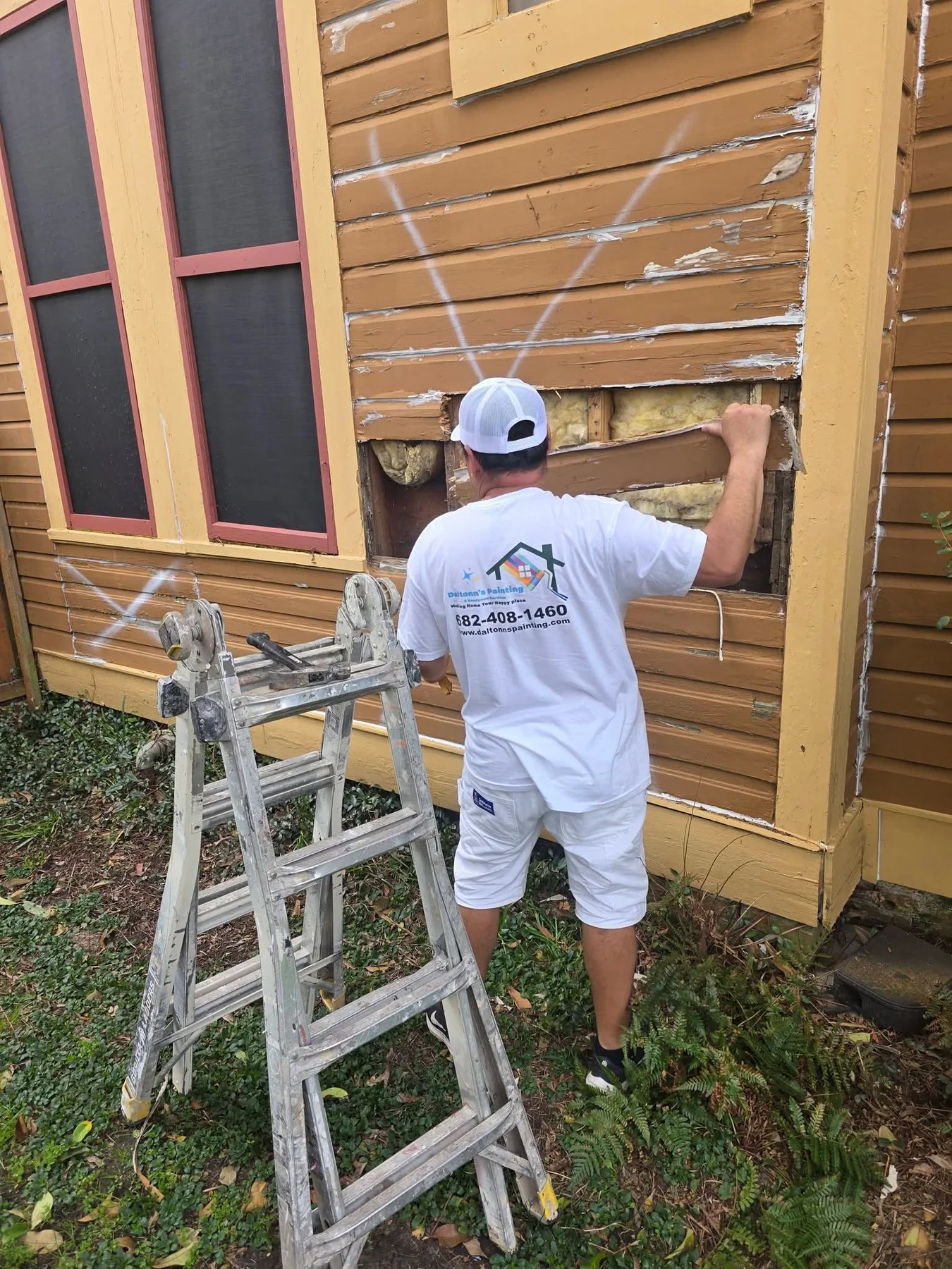 Deteriorated siding being removed to expose the repair area