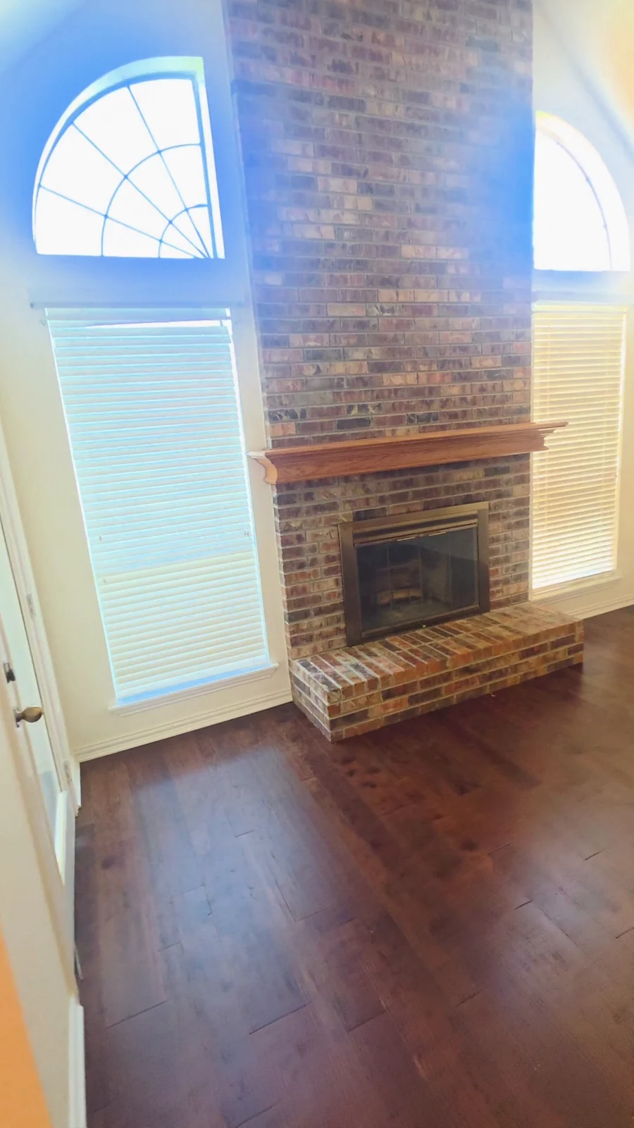 Original unpainted brick fireplace and wood mantel before the Terrell interior refresh