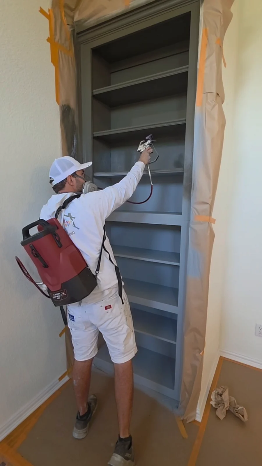 Daltonn spraying the built-in shelving during the Terrell interior refresh