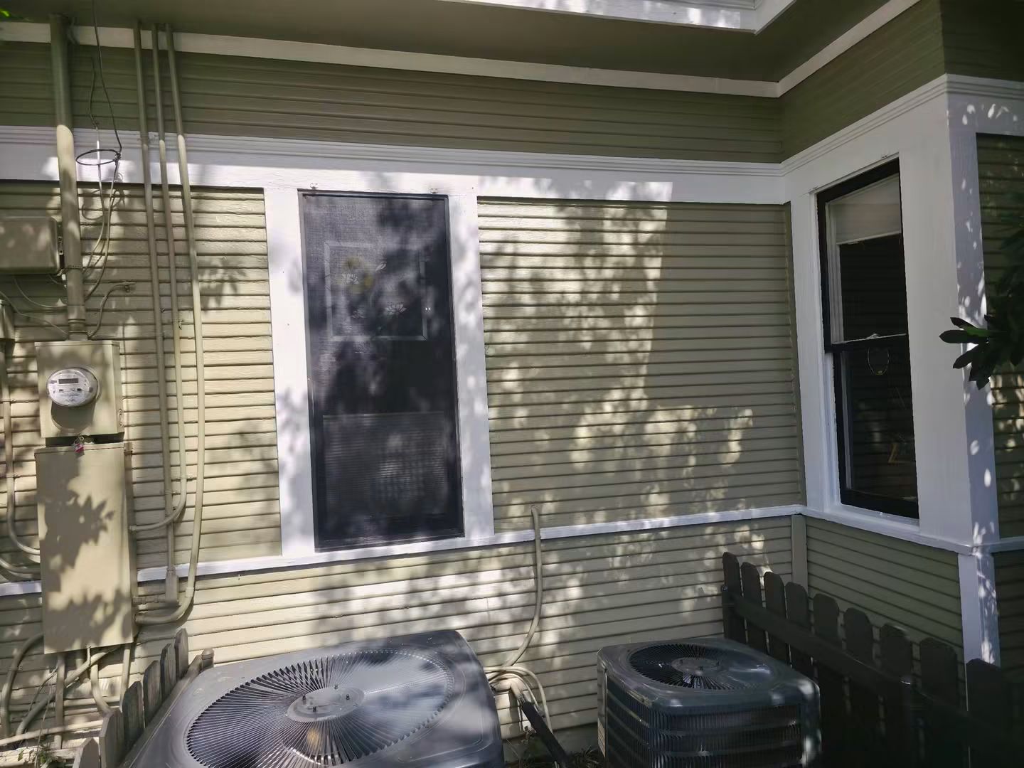 Finished utility-side exterior with restored siding, windows, lower wall, and trim