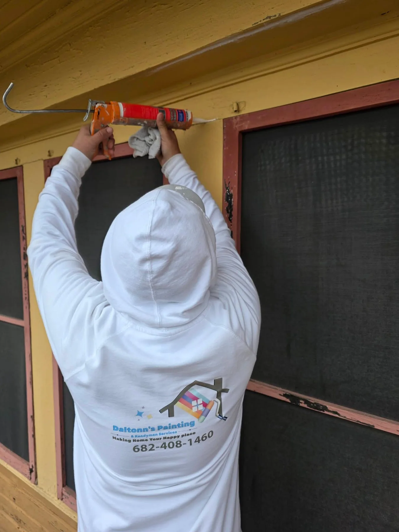 Exterior window trim being caulked during detailed preparation