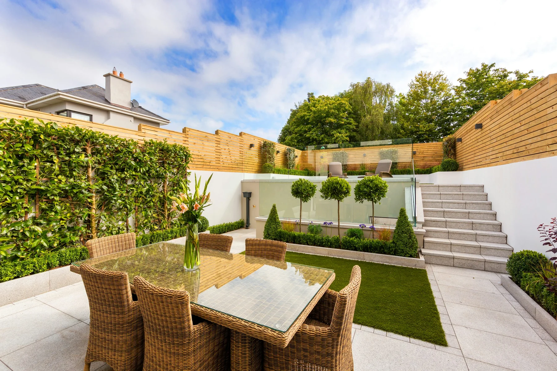 Stock photograph of a landscaped patio framed by warm horizontal wooden privacy fencing